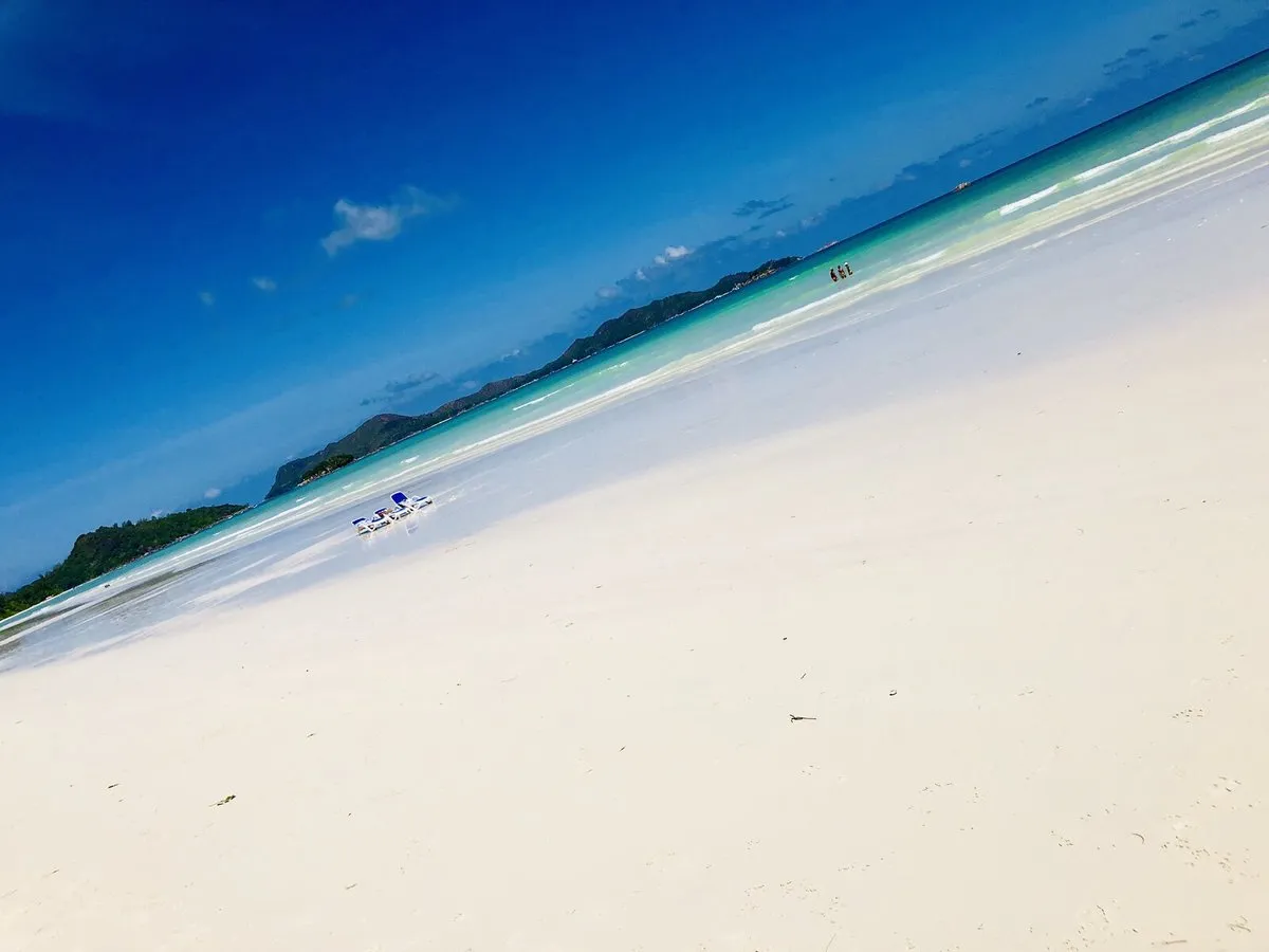 Neskončna bela peščena plaža Cote D'Or pod modrim nebom